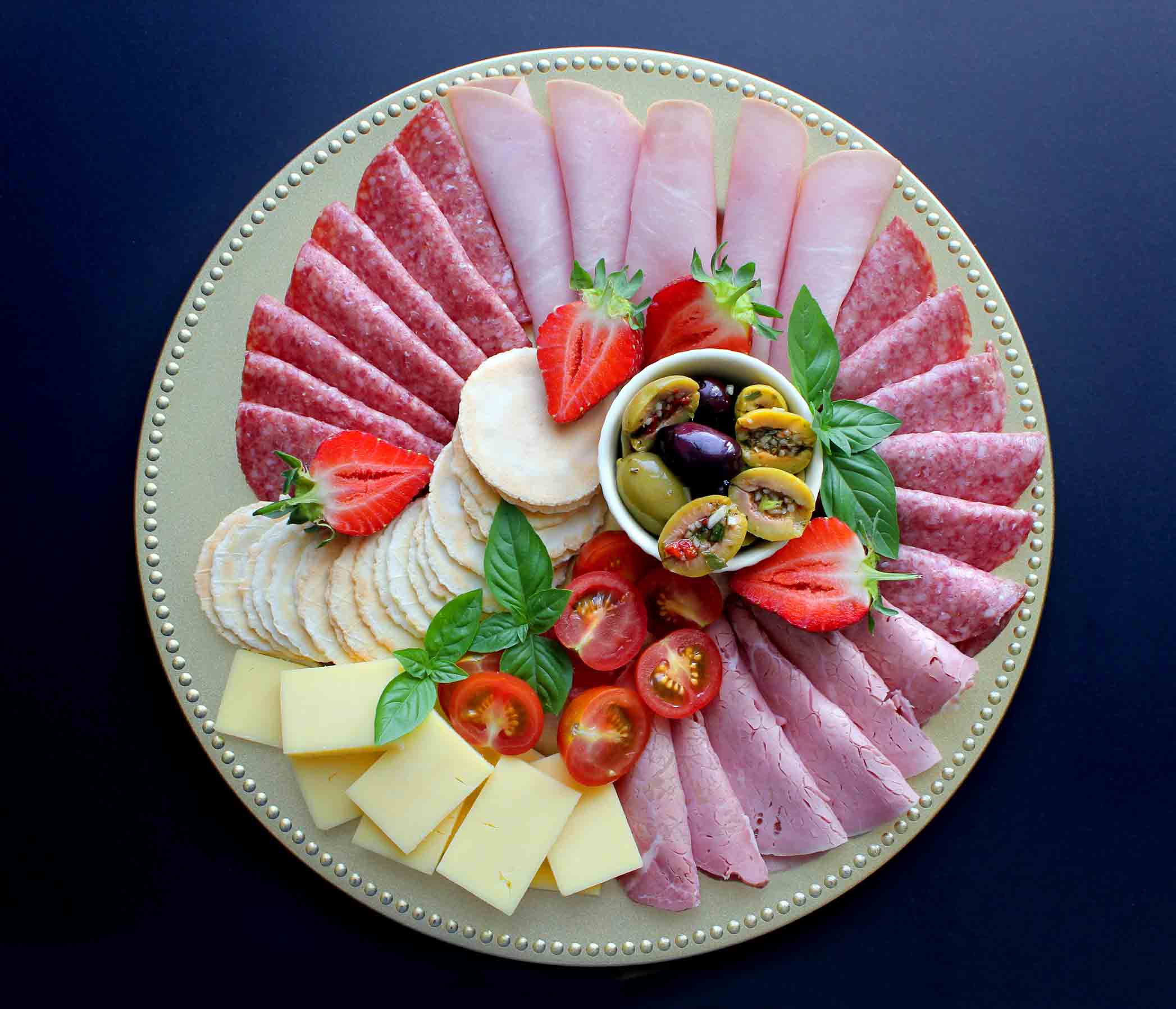 A plate with a variety of meats and cheeses on it.