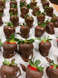 Chocolate covered strawberries on a baking sheet.