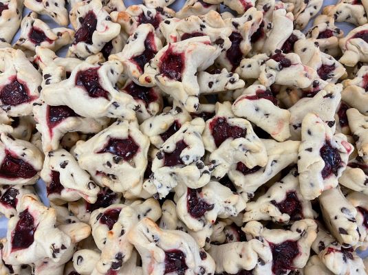 A pile of cookies with cherries on them.